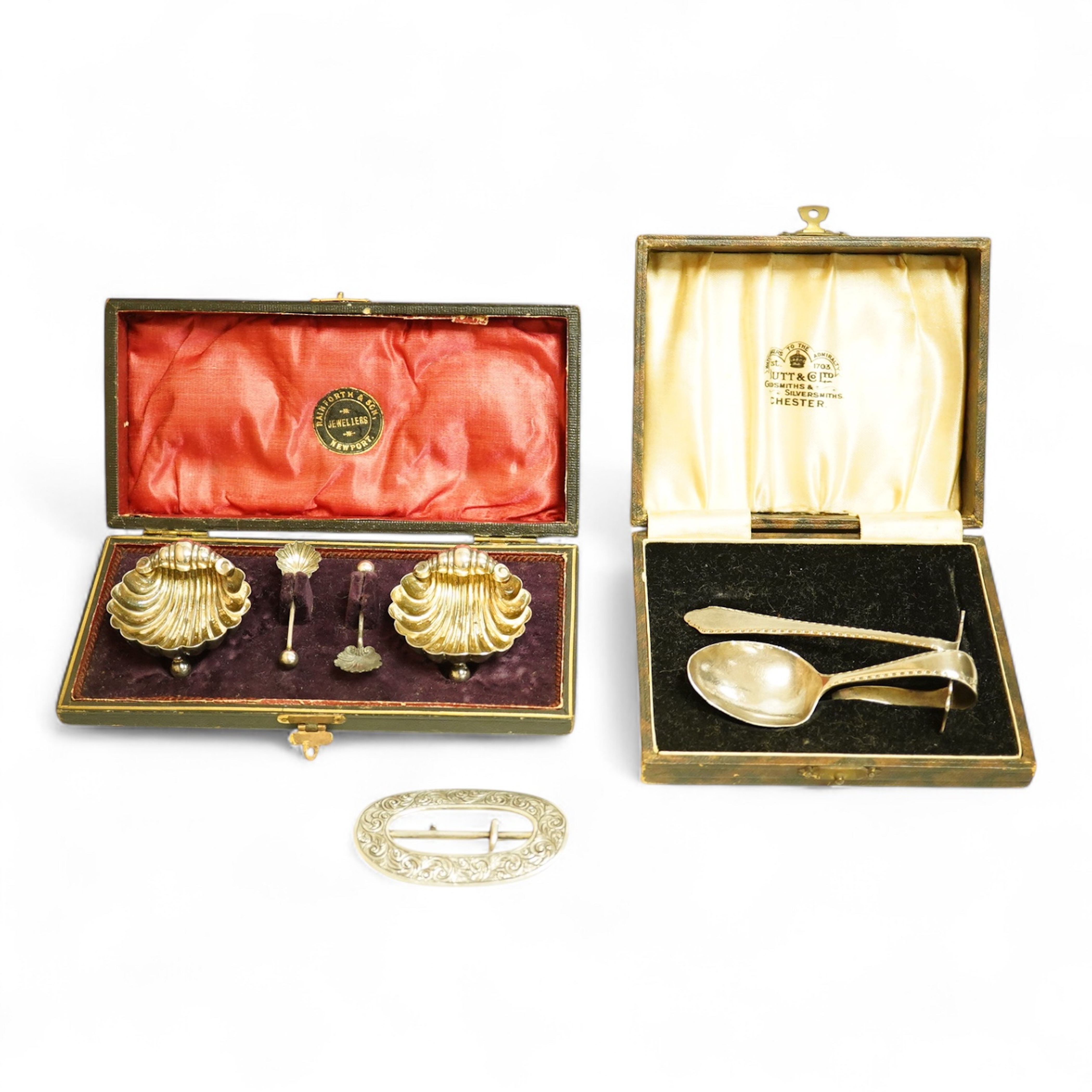A cased pair of late Victorian silver shell salts on ball feet, with matching spoons, H. Bros, Birmingham, 1895, 46mm, together with a cased George V silver spoons and pusher and a Victorian silver shoe buckle (a.f.)